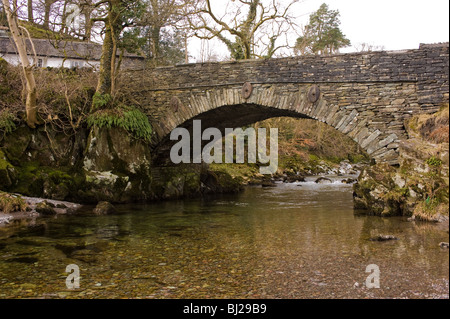 Un pont de pierre à Lakeland typique village Lake Road Crossing Elterwater Beck Parc National de Lake District Cumbria England Banque D'Images