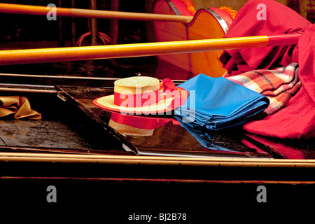 Des couleurs vives d'un gondolier's hat , sa rame et couvertures sur sa gondole poli Banque D'Images