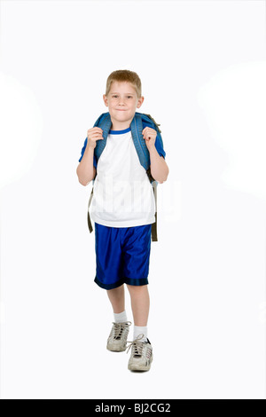 Un enfant heureux avec un sac à dos se dirige vers l'appareil photo Banque D'Images