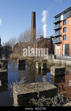 Appartements modernes contre une vieille cheminée industrielle à Kelham Island Museum à Sheffield, Mill run en premier plan Banque D'Images