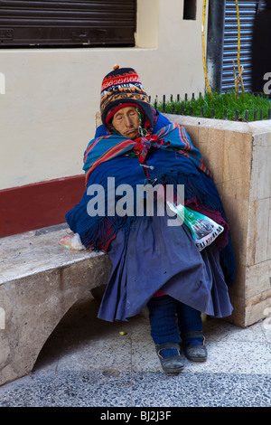 Vieille Femme dormir dans une rue de Puno, Lac Titicaca, Andes, Pérou, Amérique du Sud Banque D'Images