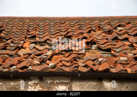 Broken et endommagé des carreaux de terre cuite sur le toit d'un bâtiment abandonné Banque D'Images