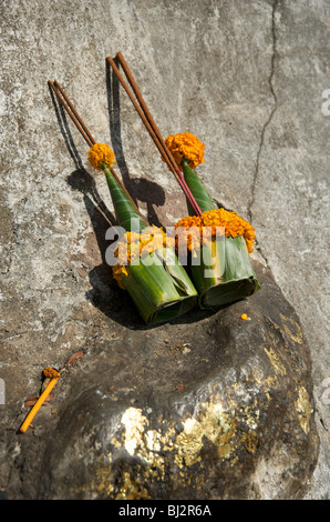 Cônes de feuille de bananier décoré de fleurs chrysanthème jaune et joss sticks offert à un sanctuaire bouddhiste Banque D'Images