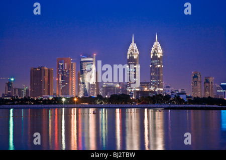 Crépuscule sur Dubai à partir de l'île Palm Jumeirah avec les deux copies du Chrysler Building à New York dans l'arrière-plan. Banque D'Images