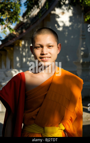 Portrait d'un moine bouddhiste novice dans le parc d'un temple à Luang Prabang au Laos Banque D'Images
