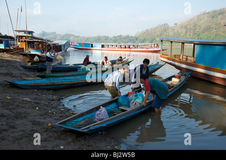 Les femmes chargées de produits frais du marché du matin de Luang Prabang a une petite rivière canoë sur le Mékong Banque D'Images