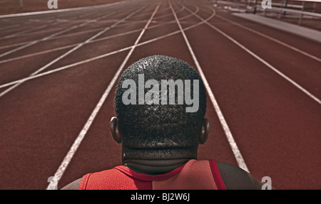 Athlète masculin le fixer d'une piste de course Banque D'Images
