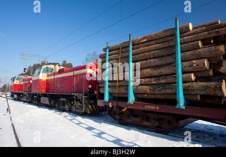 Anciennes locomotives électriques diesel finlandaises ( type dv12 ) sur la cour de chemin de fer tirant le train de grumes plein de grumes d'épicéa , Finlande Banque D'Images