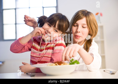 Deux filles de manger ensemble spaghetti Banque D'Images