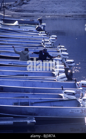 Les petits bateaux à moteur de pêche amarré avec deux hommes le lancement d'un moteur sur un lac dans les Sierras de l'Est de la Californie. Banque D'Images