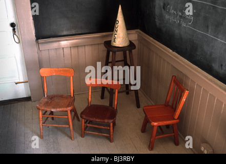 Un bonnet et les chaises de l'école par un tableau noir à l'ancienne. Banque D'Images