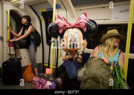 Un ballon Minnie Mouse amenés de Disneyworld, Paris, à bord d'un métro de Londres train de tube. Banque D'Images