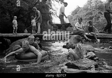 Sur un week-end d'été, les familles apprécient l'ancien Tarr Étapes Clapper Bridge sur la rivière Barle au Parc National d'Exmoor. Banque D'Images