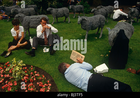 Regardant vers le bas sur les travailleurs et les entreprises de bureau qui sont couchés et reposant dans l'herbe dans leur pause déjeuner à Finsbury Circus Banque D'Images