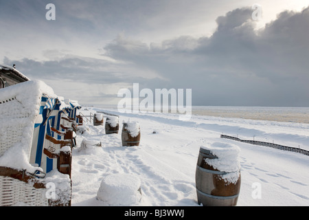 Des chaises de plage en osier avec vue sur un paysage de neige et de glace sur la plage sud de Wyk de la mer du Nord île de Foeh Banque D'Images