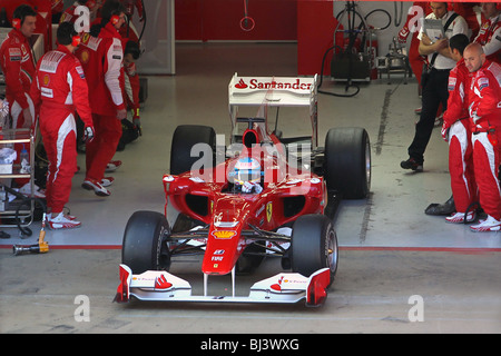 Fernando Alonso de l'équipe Ferrari 2010 de quitter les stands sur le circuit de Montmelo, Barcelone, Espagne Banque D'Images