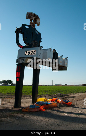 Un robot d'acier figure détient cinq boîtes mail sur une route rurale en Californie. Banque D'Images