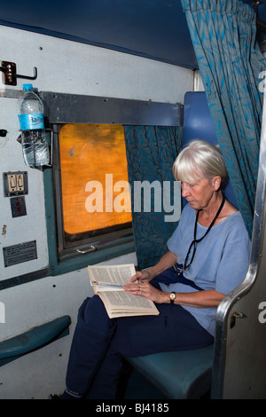 L'Inde, les voyages en train touristique, livre de lecture à deux vitesses de deuxième classe air conditionné (2A) habitacle Banque D'Images