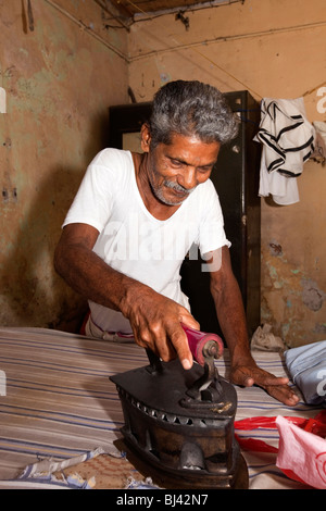 L'Inde, le Kerala, Calicut, Kozhikode, Kuttichira Halwa, Bazar, old man ironing clothes Banque D'Images