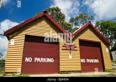 Central Tilba main Street architecture historique Central Tilba Australia // CENTRAL TILBA, Australia — la station 18 de la Central Tilba Volunteer Bush Fire Brigade est logée dans ce bâtiment jaune distinctif avec des portes de garage rouges. Le bâtiment présente une architecture rurale australienne classique et sert de ressource communautaire vitale dans le village historique de Central Tilba, en Nouvelle-Galles du Sud. Banque D'Images