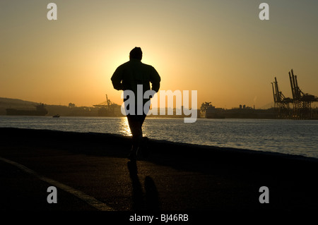 Jogger s'exécute à l'aube le long de la digue du parc Stanley à Coal Harbour, Vancouver, British Columbia, Canada Banque D'Images