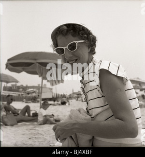 Mode femme à la plage durant les années 1950. smiling happy parapluies mode soleil Lunettes de l'Atlantique de l'océan Banque D'Images