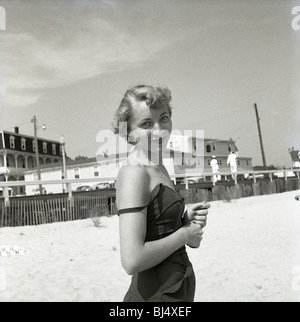 Mode femme à la plage durant les années 50 sourires pour portrait. maillot de bain. smiling happy fashion soleil parasols ocean Banque D'Images