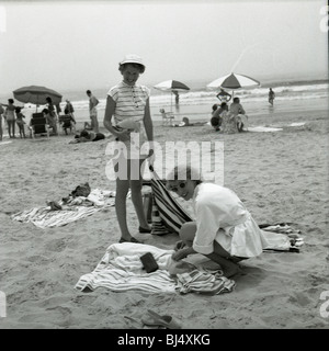 Mode femme à la plage durant les années 1950. smiling happy fashion soleil parasols serviettes de plage de l'Atlantique de l'océan Banque D'Images