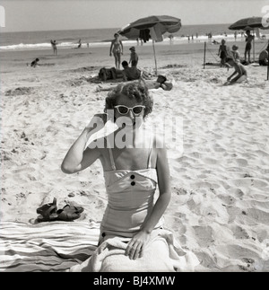 Mode femme à la plage durant les années 1950. smiling happy parapluies robe soleil océan atlantique Banque D'Images