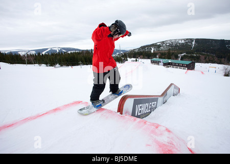 Snowboardeur dans un parc de terrain lors d'une journée d'hiver couvert à les montagnes Banque D'Images