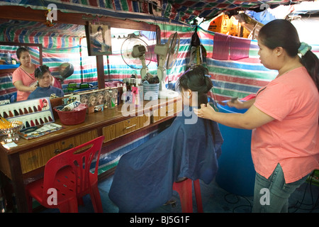 Un coiffeur travaille avec un client à Vientiane, République démocratique populaire lao. Banque D'Images