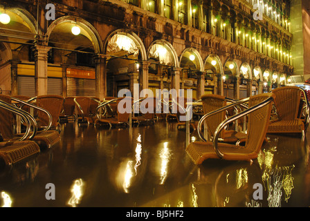 Scène de nuit de chaises en St Mark's Square cafe pendant une inondation, Venise, Italie Banque D'Images