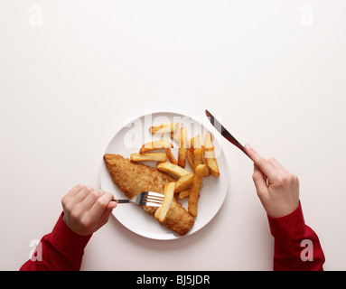 Mains par assiette de poisson et frites Banque D'Images