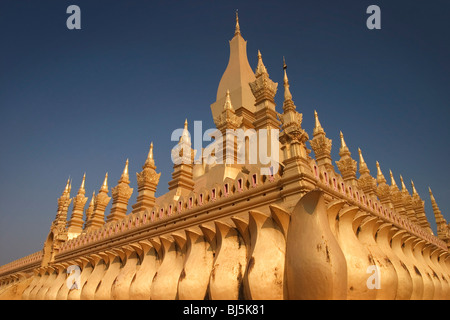 Le soleil brille sur les tourelles d'or de la pagode Pha That Luang à Vientiane, République démocratique populaire lao. Banque D'Images