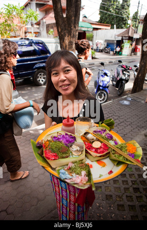 L'INDONÉSIE, Bali, Kuta, Legian Road, plaçant tous les jours femme hindoue offre à l'extérieur de l'atelier Banque D'Images