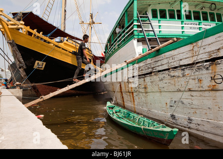 L'Indonésie, Java, Jakarta, travailleur, Sunda Kelapa walking up voile en bois passerelle Bateau cargo Banque D'Images