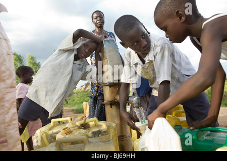 Les enfants aller chercher de l'eau potable fraîche à un forage dans la région de Teso, District Amuria, en Ouganda. Banque D'Images