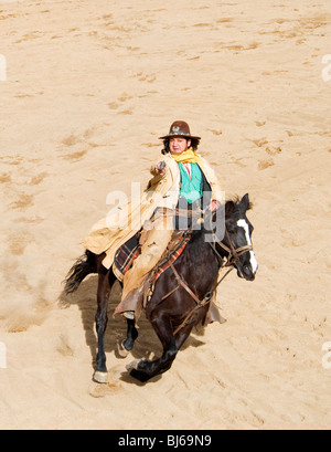 Cheval de cow-boy au grand galop tirant son arme Banque D'Images