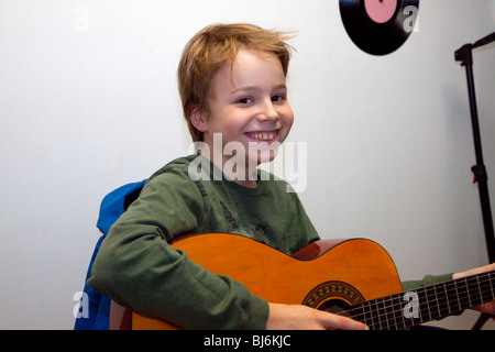 Happy boy 10 ans en tenant une guitare leçon de musique. St Paul Minnesota USA Banque D'Images