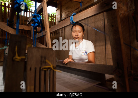 L'Indonésie, Sulawesi, Sengkang, jeune femme soie tissage à la main dans de petits ateliers locaux Banque D'Images