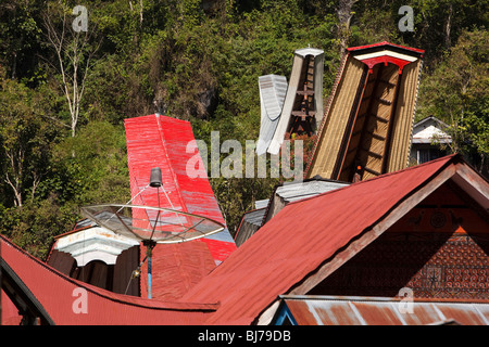 L'Indonésie, Sulawesi, Tana Toraja, Kalimbuang village, TV satellite dish entre maisons tongkonan Banque D'Images