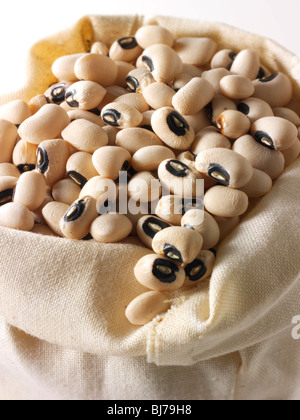 Gros plan sur des haricots noirs entiers ou des pois noirs dans un sac en toile Banque D'Images