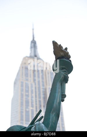 Une statue de la liberté réplique près du bras de l'Empire State Building. Banque D'Images