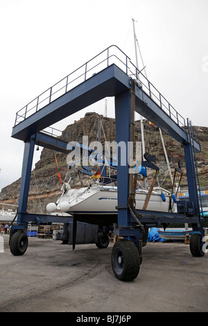 Location d'être sortis de l'océan par un palan mobile dans la marina de Puerto de Mogan Gran Canaria Banque D'Images