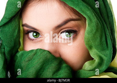 Portrait de beaux mystérieux Caucasian Hispanic Latina woman face aux yeux pénétrants vert et vert écharpe de mode d'enrubannage. Banque D'Images