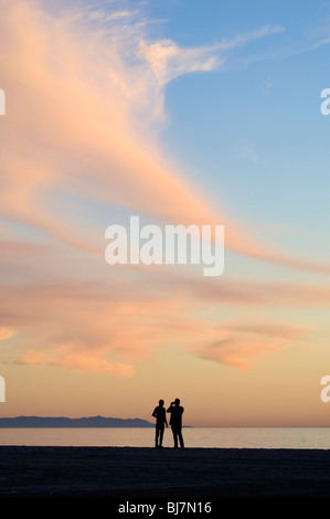 Photographier les gens sur la plage au coucher du soleil Banque D'Images