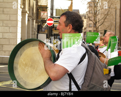 Jouant du tambour bodhran irlandais traditionnel au cours de St Patrick Day Parade à Londres Banque D'Images
