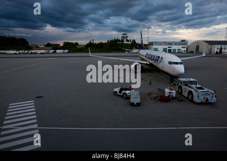 Un avion de Ryanair stationné à l'aéroport de lumière du soir sous les nuages threathening Banque D'Images