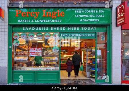 Nos acheteurs de pain quotidiens à Percy Ingle High Street Bakers font leurs courses à côté de la boutique de charité de la British Heart Foundation Brentwood Essex England UK Banque D'Images