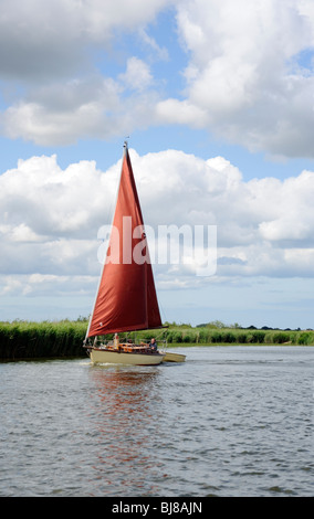 Bateau à voile avec Red Sail à Potter Heigham,Norfolk Broads, East Anglia, Angleterre, Royaume-Uni Banque D'Images